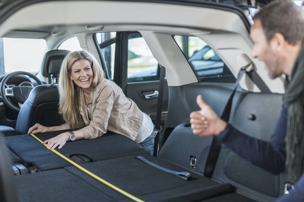 Couple examining new car at car dealer